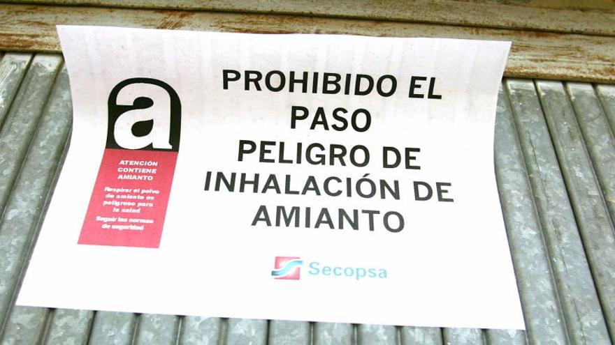 Un cartel que prohíbe el paso por la presencia de amianto.