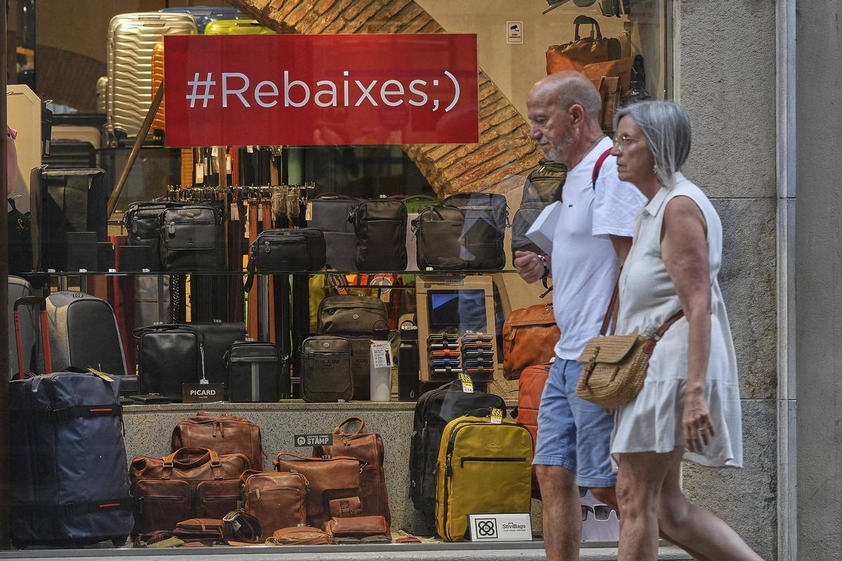 Dues persones davant l’aparador d’una botiga la centre de Girona.