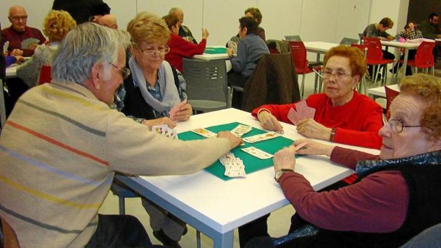 Un grup d&#039;usuaris jugant a cartes a la sala principal del Casal Cívic