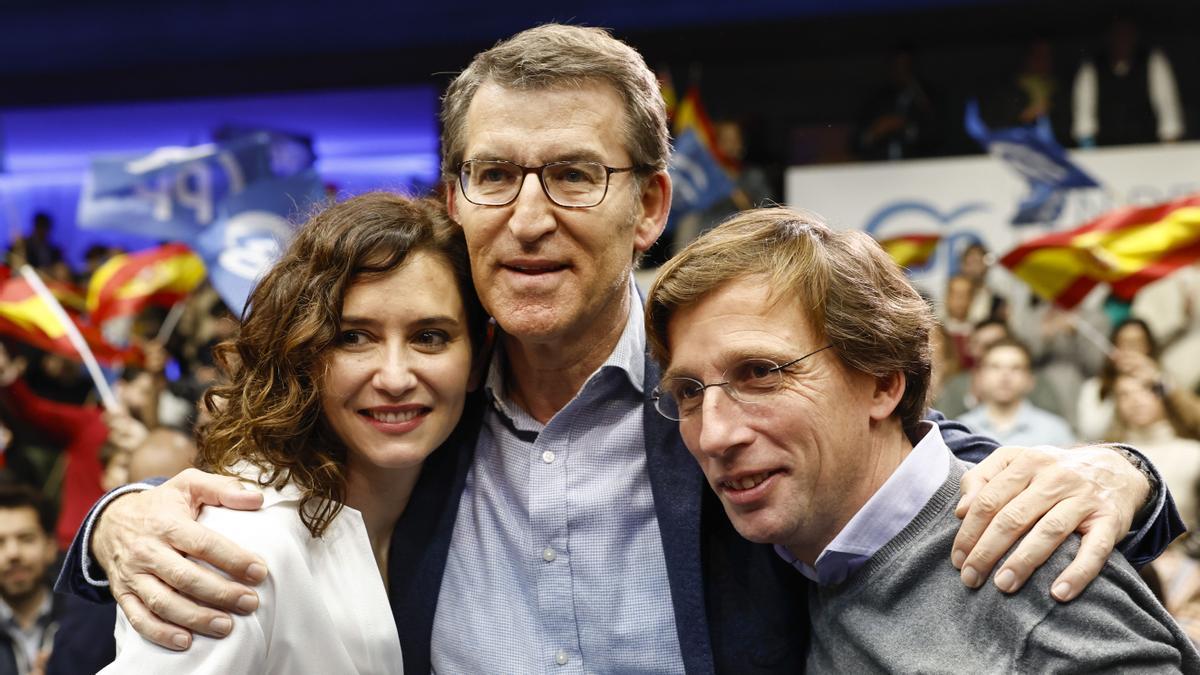 Feijóo abraza a Ayuso y Martínez Almeida, durante el acto de este sábado en Madrid.