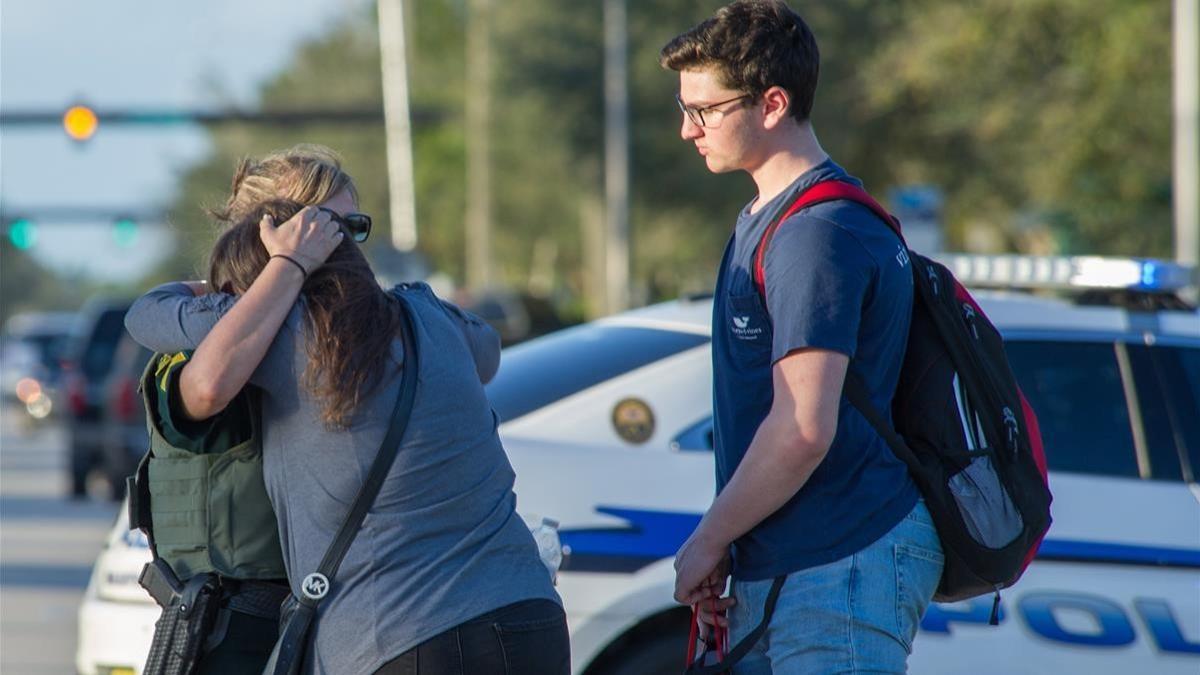 Una agente de policía consuela a una mujer tras el tiroteo en una escuela secundaria de Parkland (Florida)