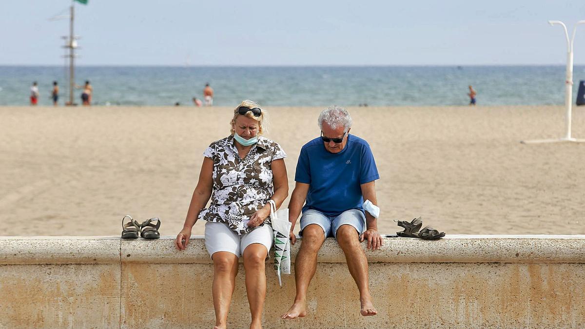 Una pareja descansa en la playa de la Malvarosa de València durante el puente del 9 d’Octubre. | EDUARDO RIPOLL