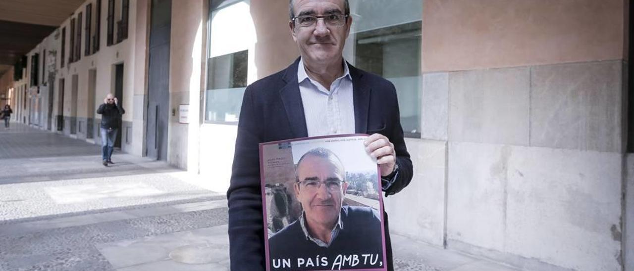 El candidato de Podemos al Congreso de los Diputados por Balears, Juan Pedro Yllanes, posa junto a su cartel electoral.