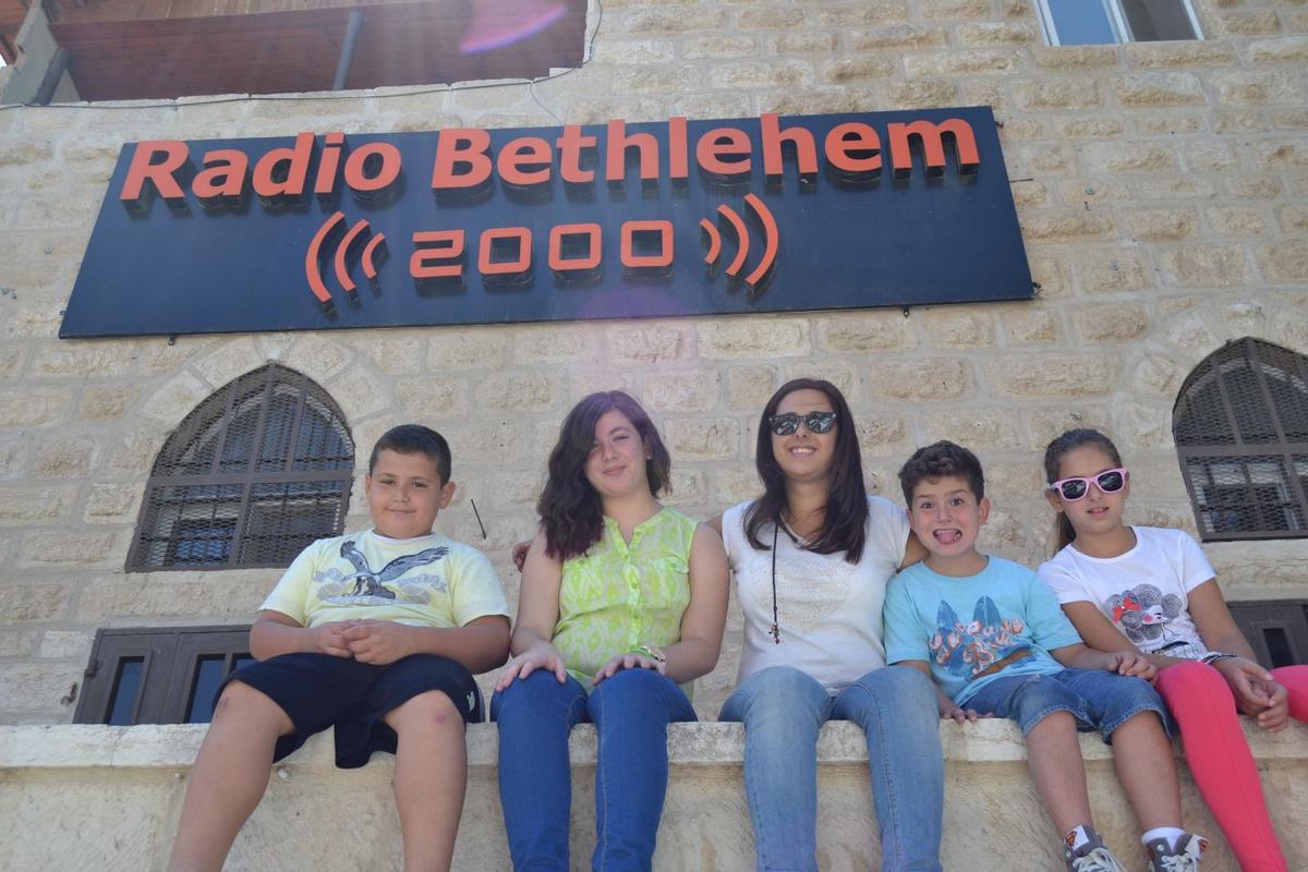 Nathaly, con sus sobrinos en la Radio de Belén en la que trabaja su hermano.