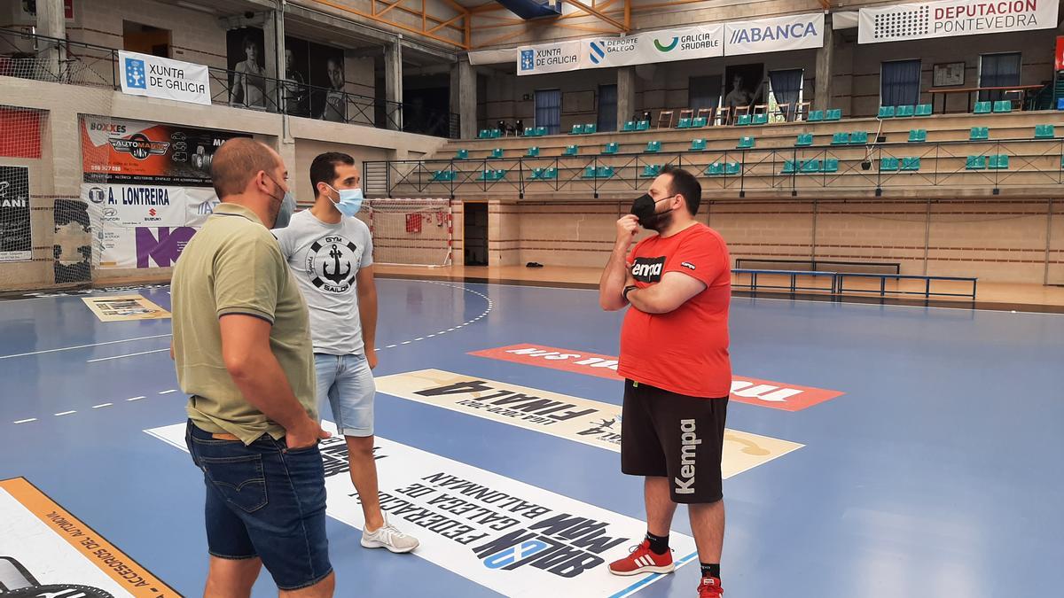 Nacho Moyano conversa ayer en o Gatañal con el director deportivo del Cangas, Óscar Fernández, y con el jugador Adrián Menduíña.