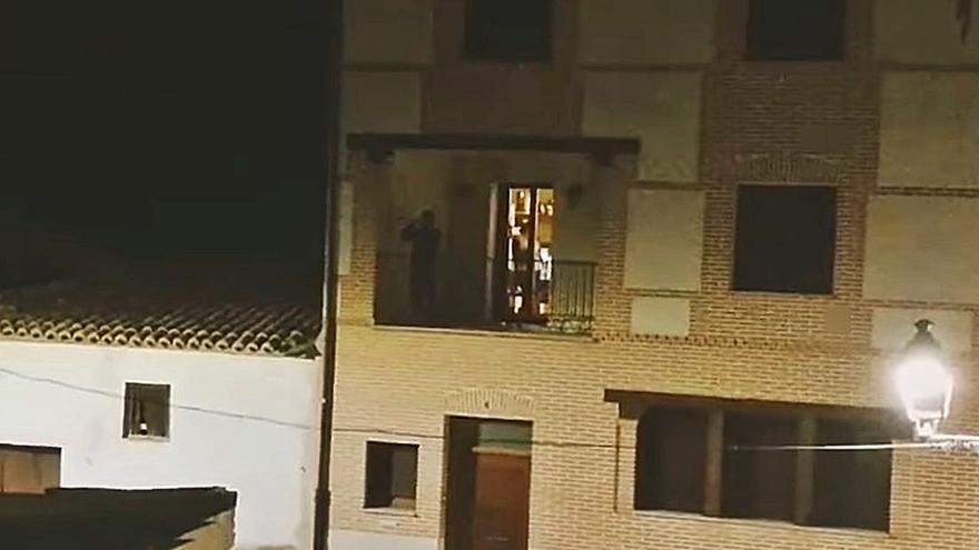 Un músico toca la corneta desde su balcón en la madrugada del Viernes Santo. | J. N.