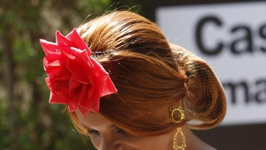 Una joven consulta su móvil en el Real de la Feria.