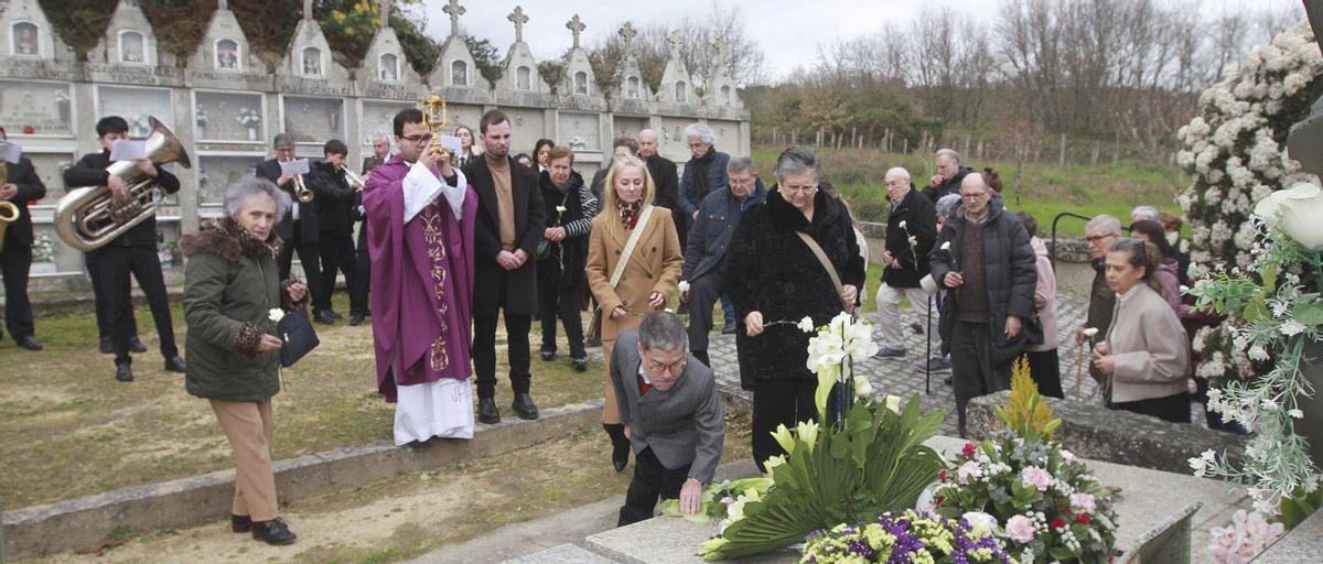 Familiares, amigos y vecinos en la ofrenda floral ayer ante la sepultura de don Adolfo. | IÑAKI OSORIO