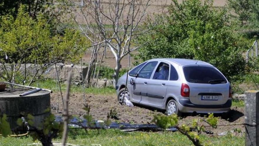 El vehículo en el que huyeron los delincuentes, abandonado tras quedar atascado en una finca.En el recuadro superior izquierdo, la imagen del hombre perseguido.  // Noé Parga