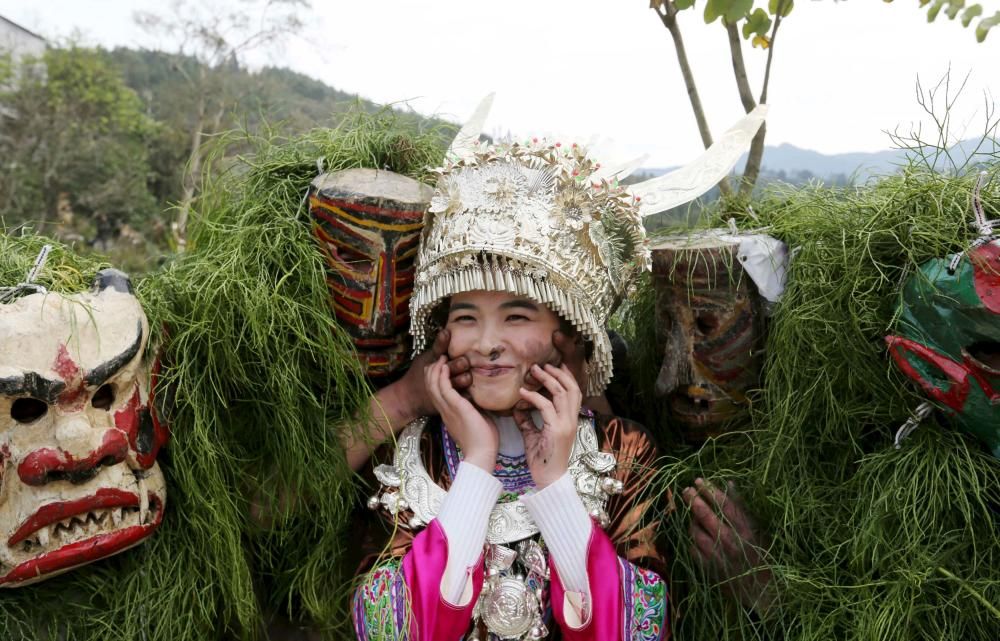 Ethnic Miao men wearing traditional masks smear ...