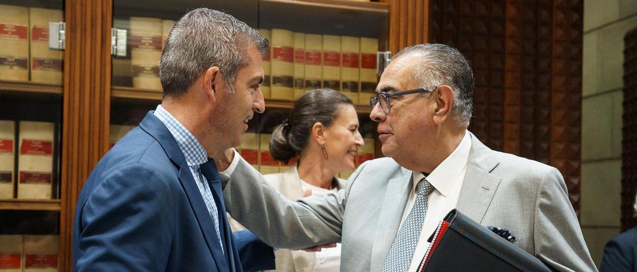El vicepresidente y consejero de Economía, Manuel Domínguez (i), conversa con el presidente del CES, José Carlos Francisco, ayer en el Parlamento.