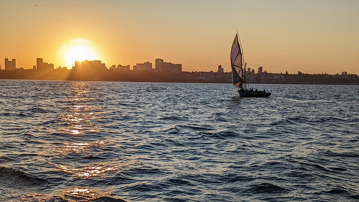 Un dhow navega al atardecer frente a Maputo, con el Índico como gran telón de fondo del viaje.
