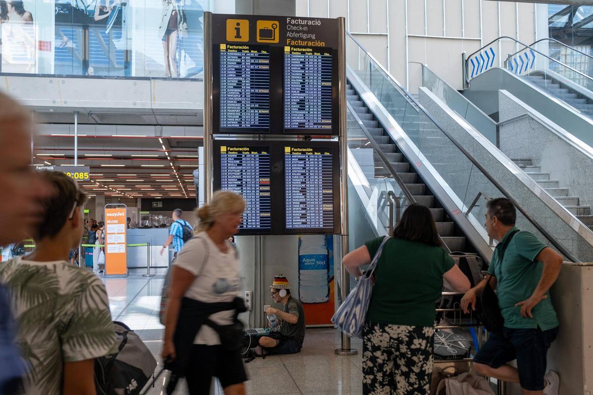 Pasajeros contemplan las pantallas con el estado de los vuelos en el aeropuerto de Palma.