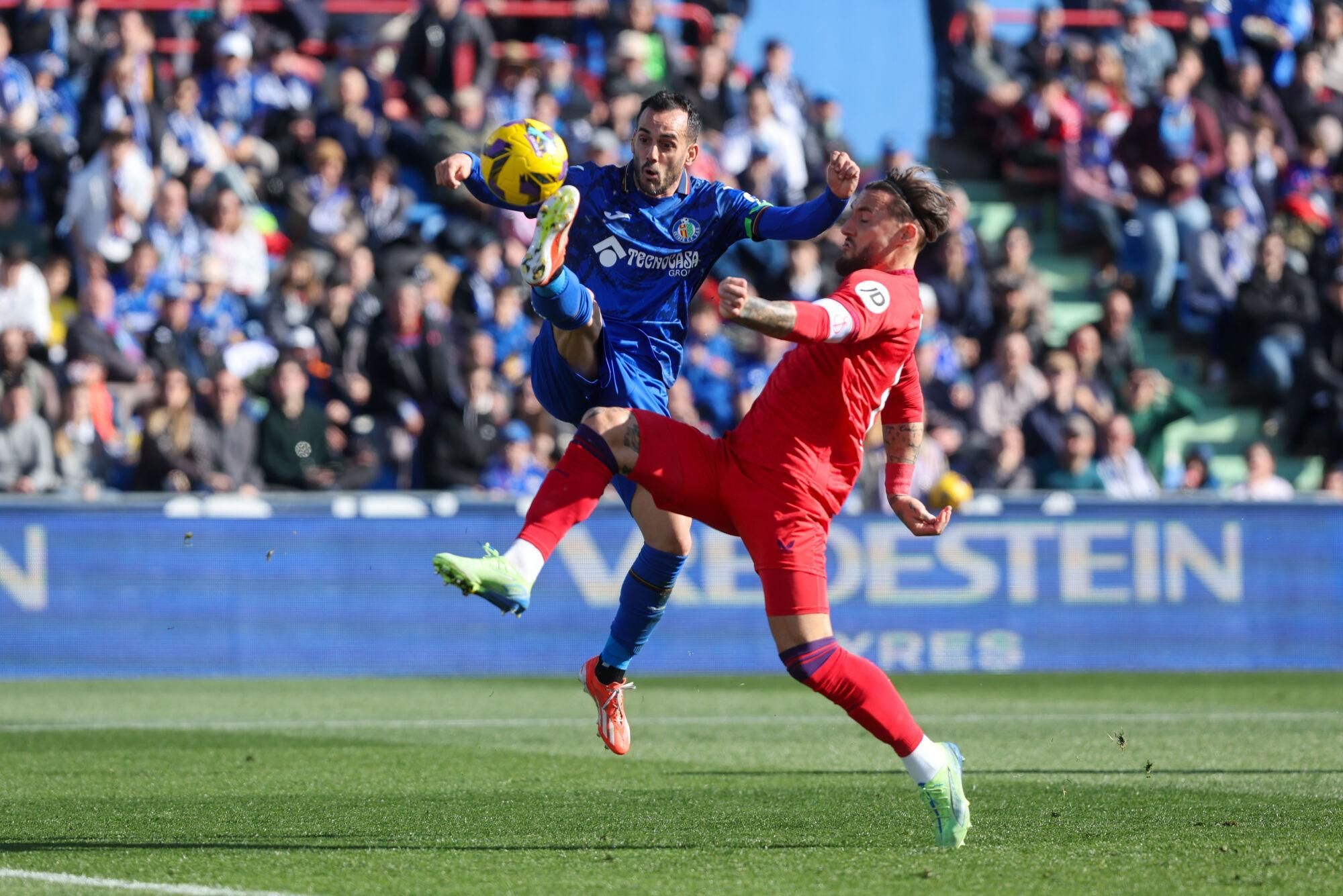 GETAFE (MADRID), 01/02/2025.- El defensa del Sevilla Nemanja Gudelj (d) lucha por el balón con el defensa Juan Iglesias (i) del Getafe durante el partido de LaLiga que enfrenta al Getafe contra el Sevilla este sábado en el Coliseum en Getafe. EFE/ Kiko Huesca