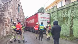 Un tráiler queda atascado en As Xubias y causa daños en casas del lugar