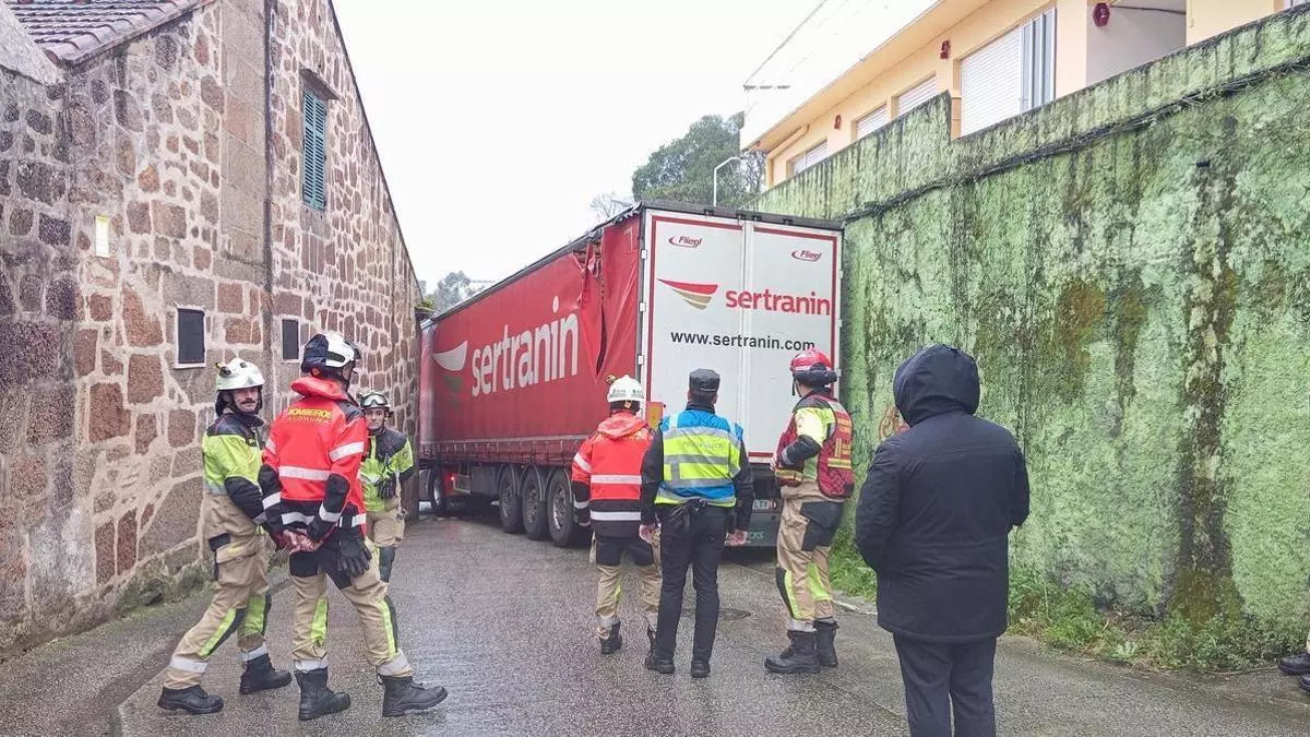 Un tráiler queda atascado en As Xubias y causa daños en casas del lugar