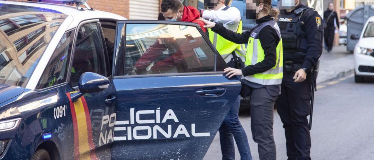 La Policía, con uno de los detenidos en Alicante. | ALEX DOMÍNGUEZ