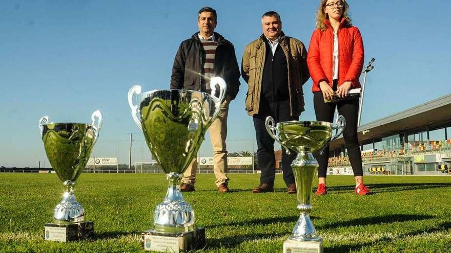 Luis González y Cristina Serantes, flanqueando al alcalde David Castro, muestran los trofeos. // N. Parga