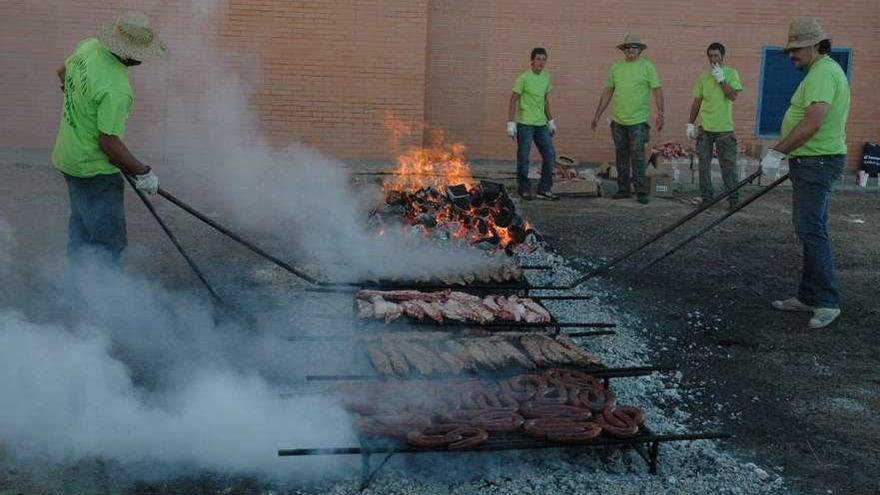 Un grupo de personas procede a sacar adelante la parrillada de Muelas en un anterior festejo.