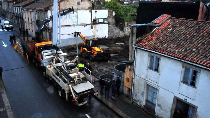 Varios vecinos observan el trabajo de los albañiles.