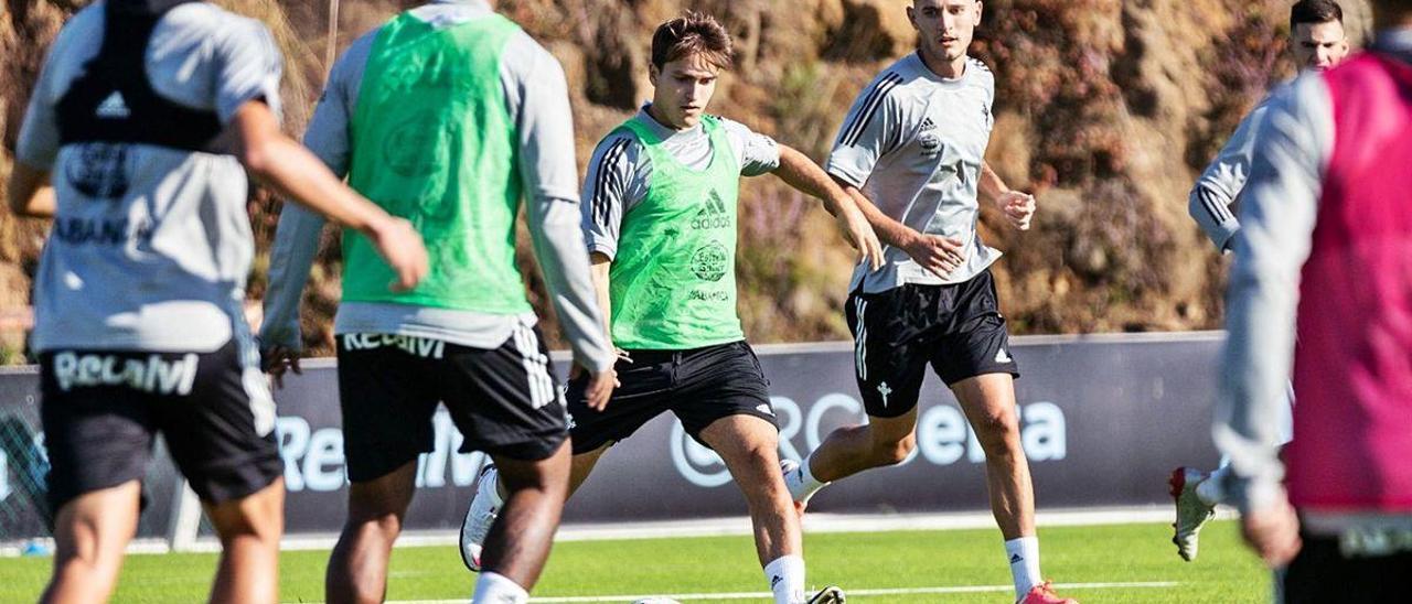 Denis Suárez, junto a Jorge Sáenz, conduce el balón durante el entrenamiento de ayer en A Madroa.