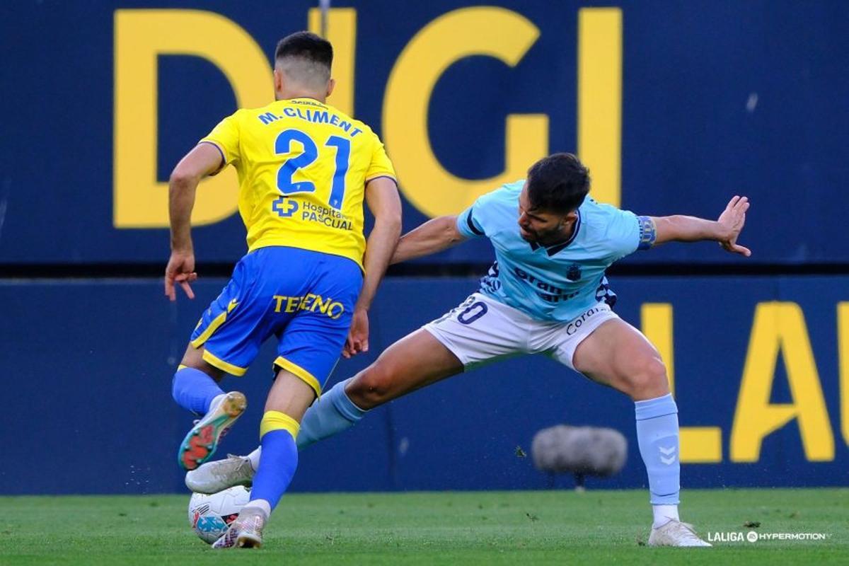 Kirian Rodríguez trata de proteger el balón ante Climent.
