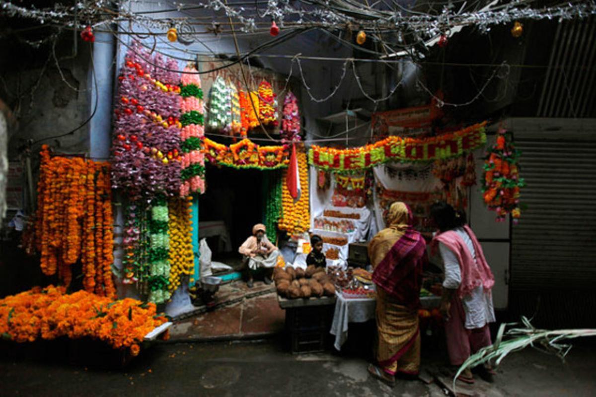 Dones índies compren adorns florals i material d’oració per celebrar el festival hindú de Diwali en una botiga a Nova Delhi (Índia).