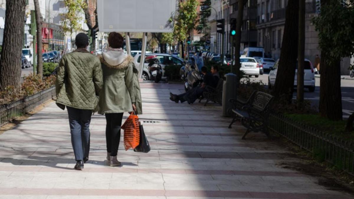 Una pareja paseando por una calle de Madrid.