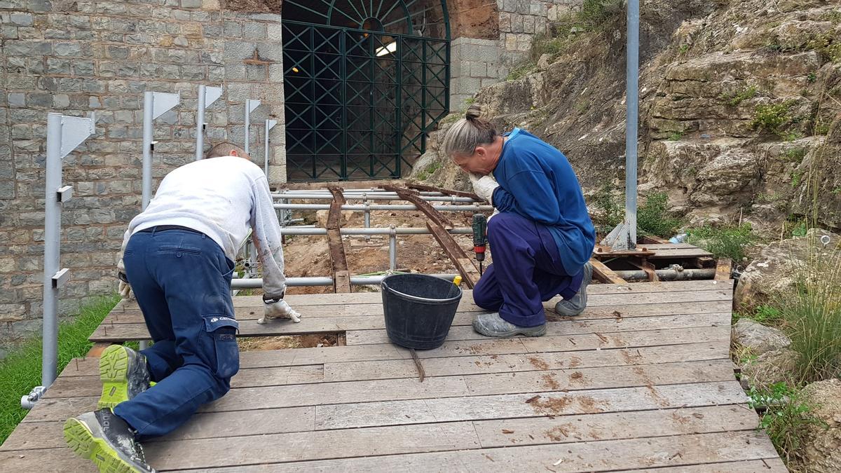 Dos operarios, retirando el viejo contrachapado en una salida lateral del Teatro Romano.