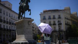 Una mujer se protege del calor con un paraguas este viernes en el centro de Madrid.