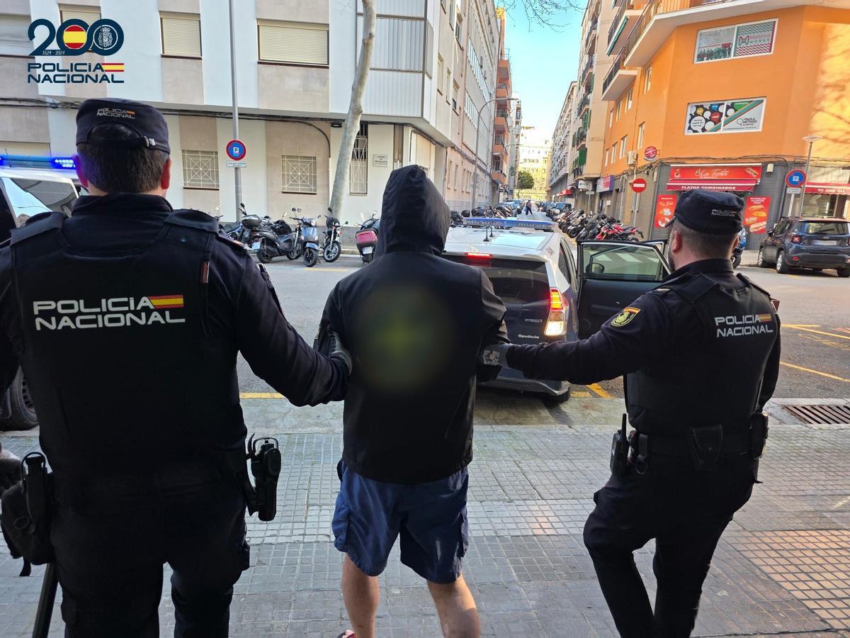Dos policías trasladan a uno de los detenidos.