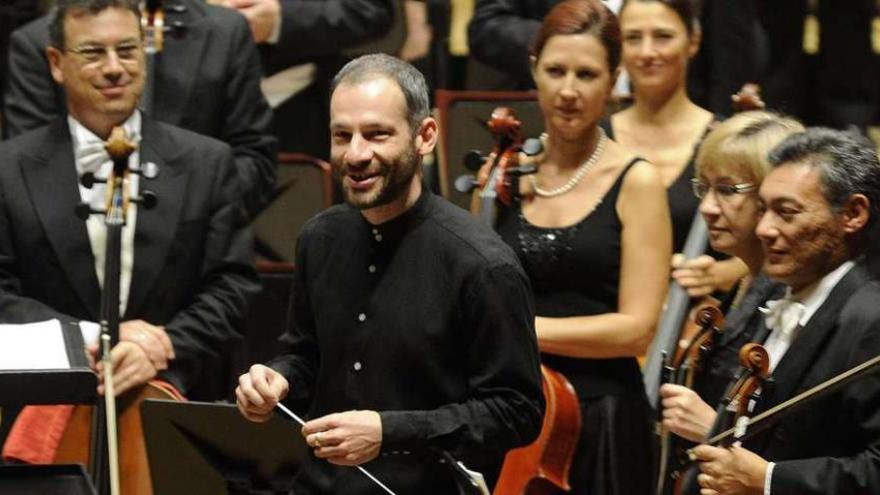 El director Dima Slobodenoiuk, con la batuta en el centro, en un concierto de la Orquesta Sinfónica de Galicia. carlos pardellas