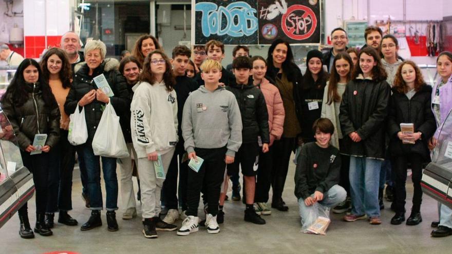 Alumnos y profesores del instituto Rafael Puga Ramón, este lunes en el mercado de Elviña.   | // LOC