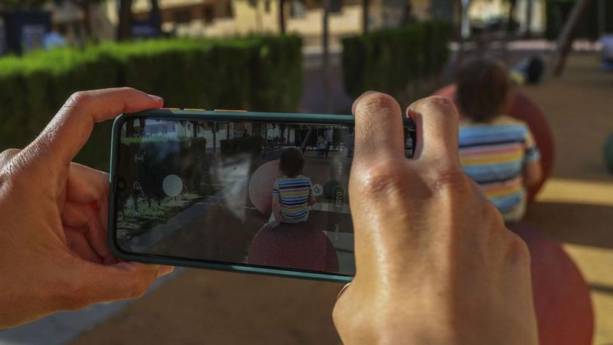 Una madre fotografía a su hijo en el parque, de archivo. / FRANCISCO CALABUIG