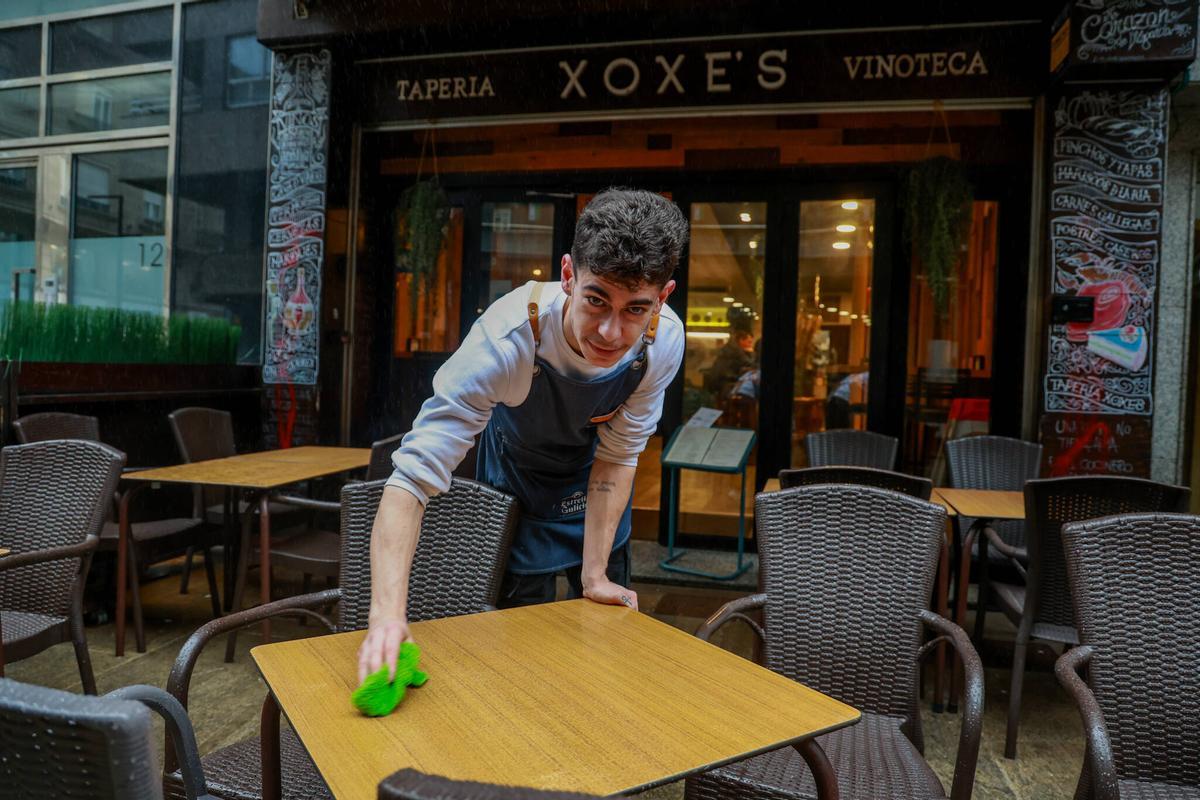 Un camarero limpiando una terraza.