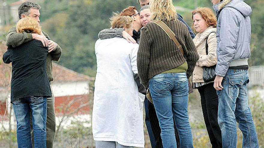 Familiares y vecinos esperan desconsolados en el lugar donde aparecieron las ropas