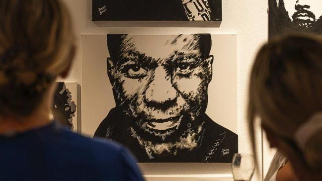 Dos mujeres contemplan los retratos de Davey Brown. | NICOLÁS FERNÁNDEZ MARÍ