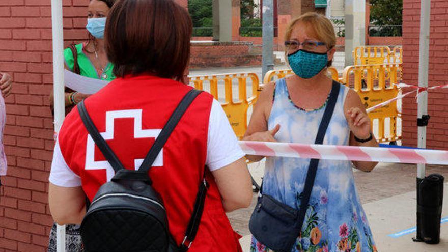 Voluntària de Creu Roja atenent una ciutadana a Cornellà.