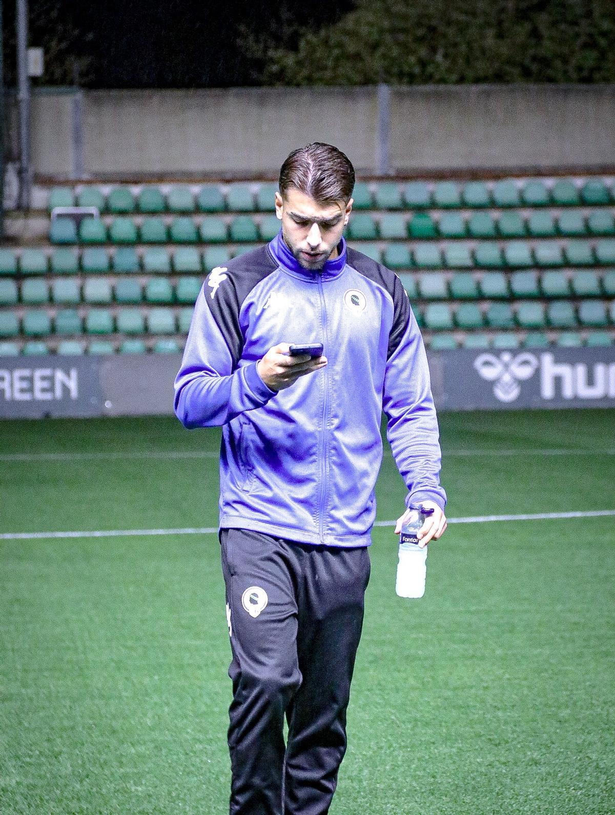 Jorge Galvañ consulta su teléfono en la toma de contacto del equipo con el césped del Luis del Sol.