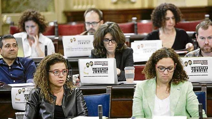 Diputados de Més muestran su apoyo a los presos catalanes en un pleno del Parlament el pasado año.