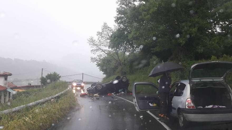 El coche de la joven, volcado sobre la carretera.