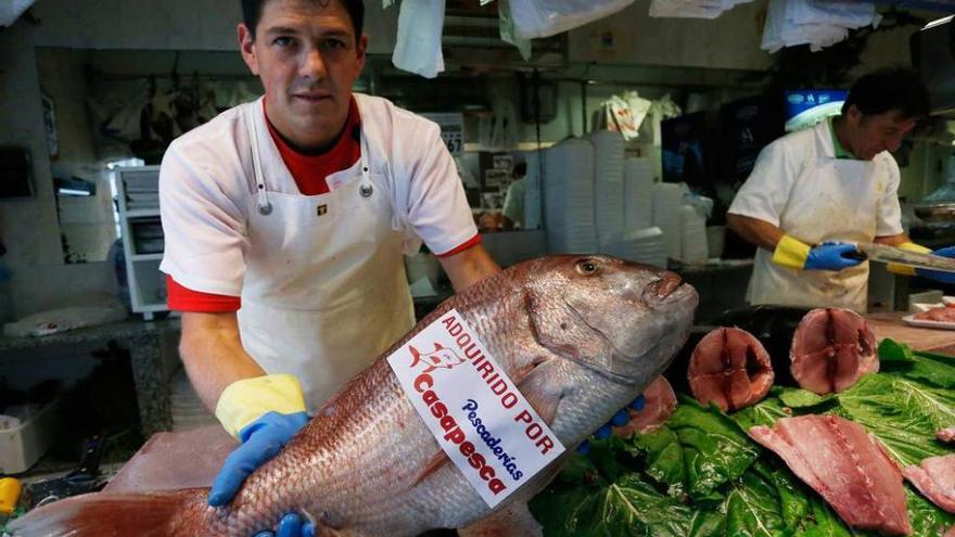 Un pescadero mostrando el pez de ocho kilos, ayer.