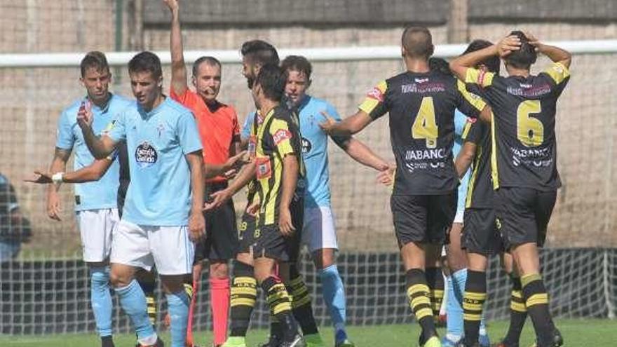 El colegiado amonesta a un jugador del Rápido en Barreiro. // E.A.