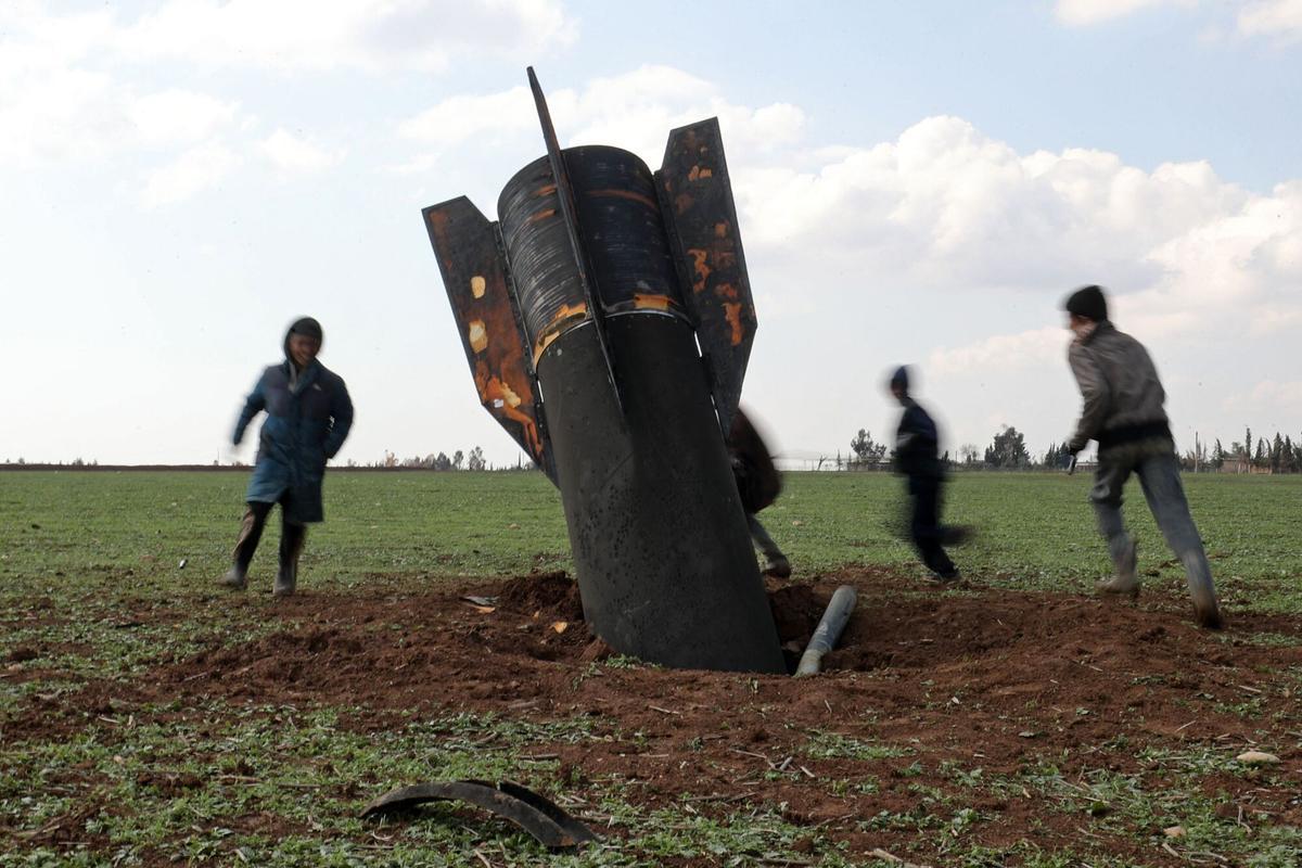 Qamishli, Siria 5/03/2026. Unos niños juegan alrededor de un misil sin explotar lanzado por Irán