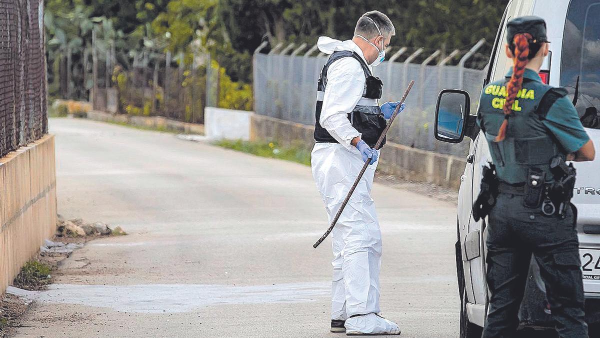 La Guardia Civil examina una barra de hierro que apareció en el lugar del homicidio.