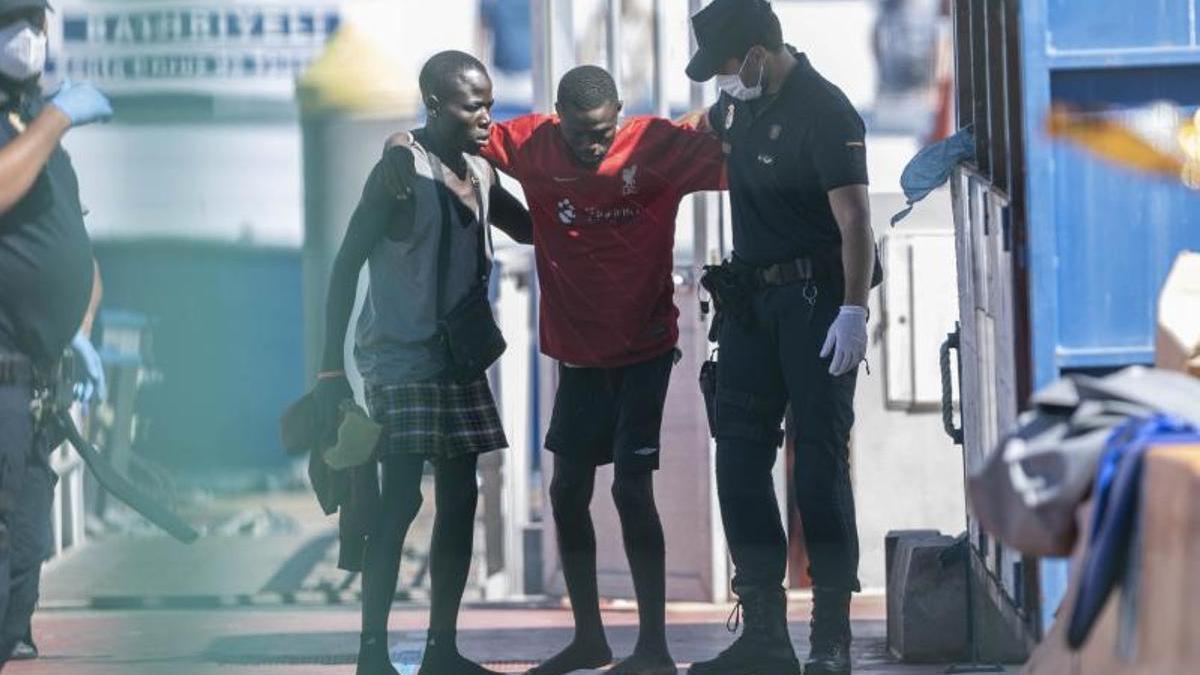 Un policía ayuda a un migrante llegado a Los Cristianos (Tenerife) el día 30.