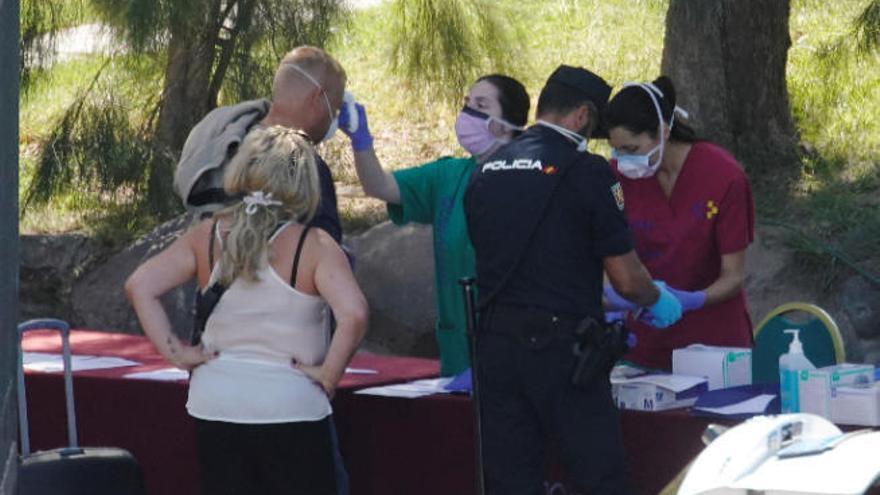 Los profesionales sanitarios toman la temperatura a los turistas que abandonan el hotel adejero.