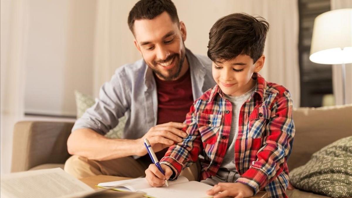 Un padre ayudando a su hijo a hacer los deberes