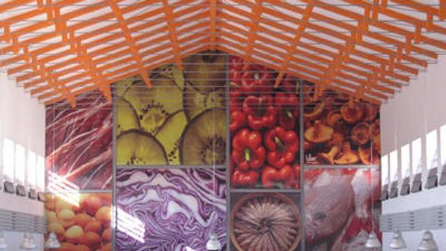 Interior. Un gran mural fotográfico con productos del mercado de Carranque, y arriba, las cerchas originales de hormigón y acero.