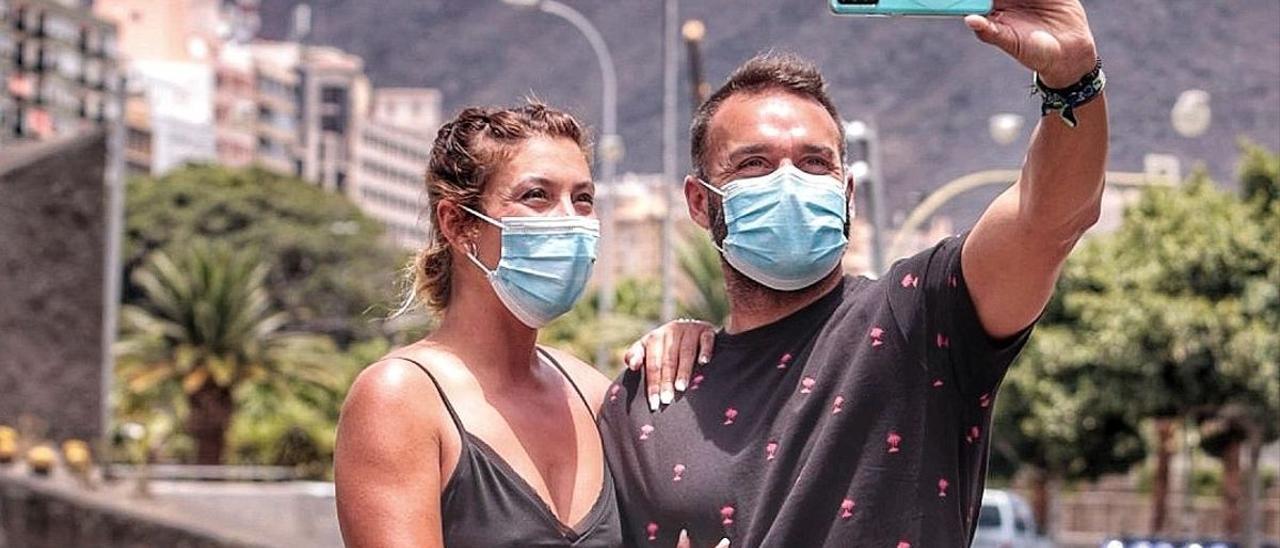 Una pareja se fotografía junto al lago de la Plaza de España.